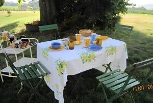 a table with a white table cloth and two chairs at Domaine Mariedal in Hauterives