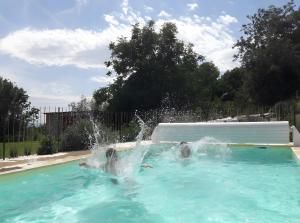 two people playing in a fountain in a swimming pool at Domaine Mariedal in Hauterives