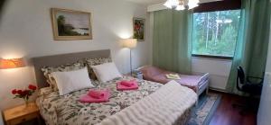 a bedroom with a bed with pink pillows on it at Saimaa Parkview Luxury Suite in Savonlinna