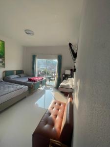 a living room with a couch and a bed at Malee Guesthouse in Ban Rak Thai +5 photos
