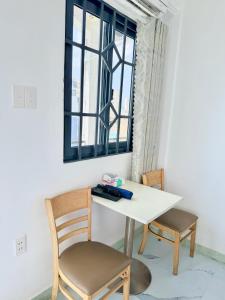 a white table with two chairs and a window at Hàng Xanh Stay in Ho Chi Minh City +13 photos