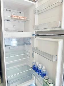 an open refrigerator with bottles of water in it at Hàng Xanh Stay in Ho Chi Minh City