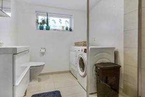 a white bathroom with a washing machine and a toilet at 30140-Malling-Askvaenget-5 in Malling