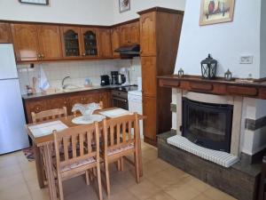 a kitchen with a table and a fireplace at Sirena House in Limenaria +24 photos