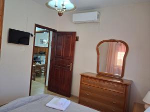 a bedroom with a mirror and a dresser with a dresserngth at Sirena House in Limenaria