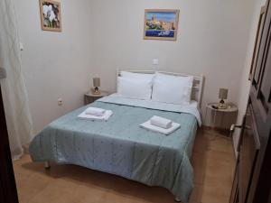 a bedroom with a bed with two towels on it at Sirena House in Limenaria
