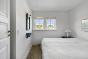 a white bedroom with a bed and two windows at 1061-N-Vejby-Lundebakken-1 in Vejby