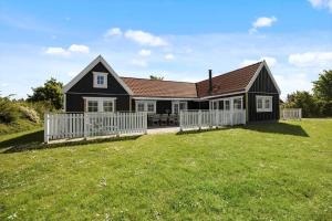 a black house with a white fence in a yard at 1061-N-Vejby-Lundebakken-1 in Vejby