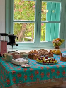 a table with baskets of fruit on a blue table cloth at LAGO Skiathos Guest Suites in Skiathos