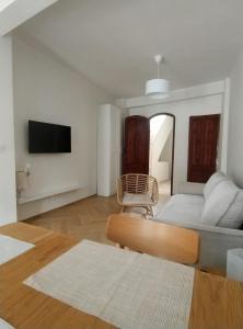 a white bedroom with a bed and a chair at Casa Medusa fun in Cullera