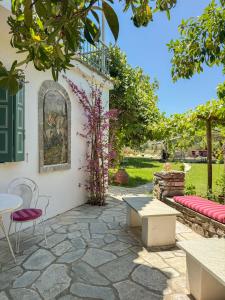 a patio with a table and chairs in a yard at LAGO Skiathos Guest Suites in Skiathos