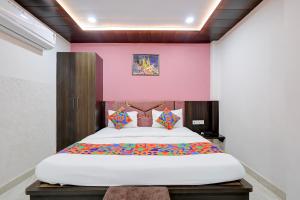 a bedroom with a large bed with a pink wall at Fabhotel Imperial 900 m from Sarnath Museum in Varanasi