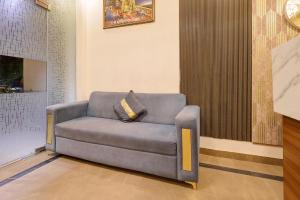 a grey couch with a pillow on it in a room at Fabhotel Imperial 900 m from Sarnath Museum in Varanasi