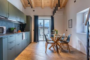 a kitchen with a table and chairs and a dining room at Alpine Lodge Green by Tss - Downtown, classy in Levico Terme