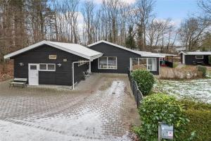 a black house with a driveway in front of it at 30640-Odder-Magevej-7 in Odder
