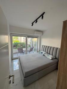 a bedroom with a bed and a large window at Stylish Ohrid Apartment, Hot Tub, Steps to Lake in Ohrid