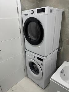 a dryer with a washing machine in a bathroom at Stylish Ohrid Apartment, Hot Tub, Steps to Lake in Ohrid