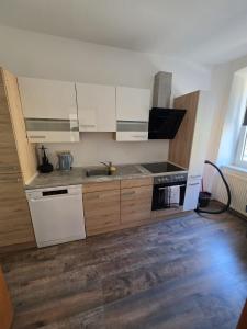 a kitchen with white cabinets and a sink at Monteur-Apartment Kusel City in Kusel +10 photos