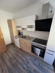a kitchen with white cabinets and a stove top oven at Monteur-Apartment Kusel City in Kusel