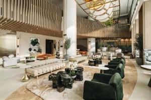 a lobby with couches and tables in a building at Pullman Dubai Jumeirah Lakes Towers in Dubai