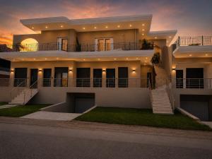 a large house with a sunset in the background at Salsedo Seaside Rooms in Kanali