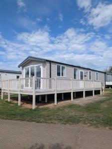 a mobile home with a large porch and a deck at Seaside Haven Hunstanton 2026 Model in Hunstanton