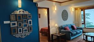 a living room with a blue couch and a bedroom at Anandam in Mashobra