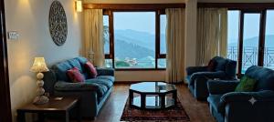 a living room with two blue couches and a table at Anandam in Mashobra