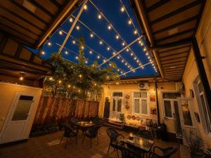 a room with tables and chairs and a ceiling with lights at Sole Family Guesthouse in Samarkand