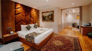 a bedroom with a large white bed in a room at The Olive Hotel Srinagar in Srinagar
