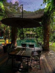a patio with a table and chairs and an umbrella at Chandra Residence in Chiang Mai