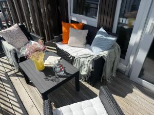 a patio with two couches and a coffee table at Moderne toppleilighet i Bergen in Bergen