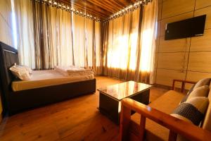 a room with a bed and a couch and a table at devdaar hills homes cafe & resort in Mussoorie