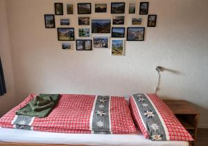 a bed with a red blanket and pictures on the wall at "Mon Rêve" Nature, Tranquility & Lake Thun in Sigriswil