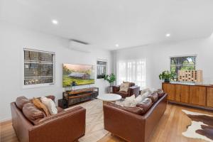 a living room with two couches and a table at La Mer in Marcoola in Marcoola