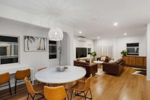 a living room with a table and chairs at La Mer in Marcoola in Marcoola