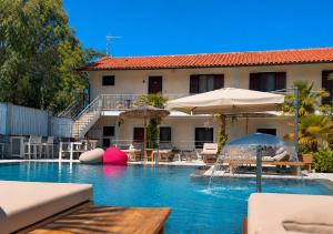 a swimming pool with an umbrella and a building at Hotel Laura in Velipojë