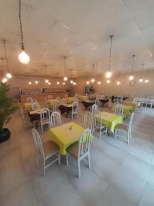 a dining room with tables and chairs and lights at Matsapha Hotel in Mahlanya