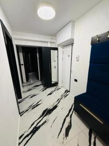 a living room with a marble floor and a blue couch at Apartament Plaja Neversea in Constanţa