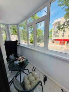 a room with a table and chairs and windows at Apartament Plaja Neversea in Constanţa