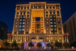a large building with a lit up facade at night at Khalidia Palace Hotel Dubai in Dubai
