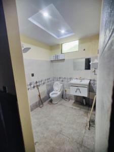 a bathroom with a toilet and a sink at Stylish Apartment in Khaira Gali