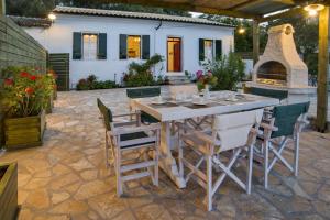 a patio with a table and chairs and a fireplace at Villa Eleonas in Ieromónachos