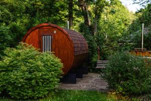 a wooden hobbit house in a garden with a bench at Agroturystyka Akacjowe Zacisze- pokoje ze śniadaniami, sauna, balia, tarasy wśród drzew, slow life in Stańkowa