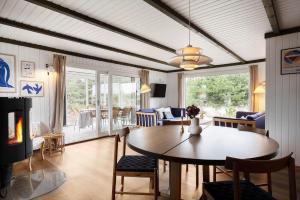 a living room with a table and chairs and a fireplace at 1115-Ringkobing-Nordsovej-466 in Søndervig