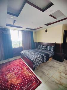 a bedroom with a bed and a red rug at Stylish Apartment in Khaira Gali