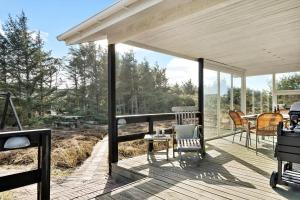 a wooden deck with chairs and a table on it at 1115-Ringkobing-Nordsovej-466 in Søndervig