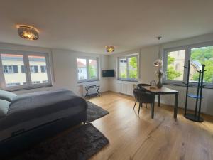 a bedroom with a bed and a table and windows at TIME OUT Apartments in Balingen