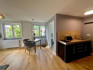 a living room with a table and a kitchen at TIME OUT Apartments in Balingen