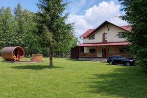 a house with a car parked in the yard at Fenyves Home in Izvoare